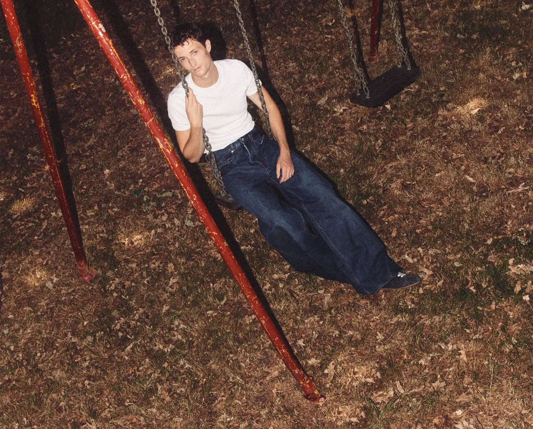 Henry Moodie - Mood Swings Album Cover showing Henry swinging on a red swing set in a park at night.